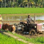 man riding farm equipment during daytime
